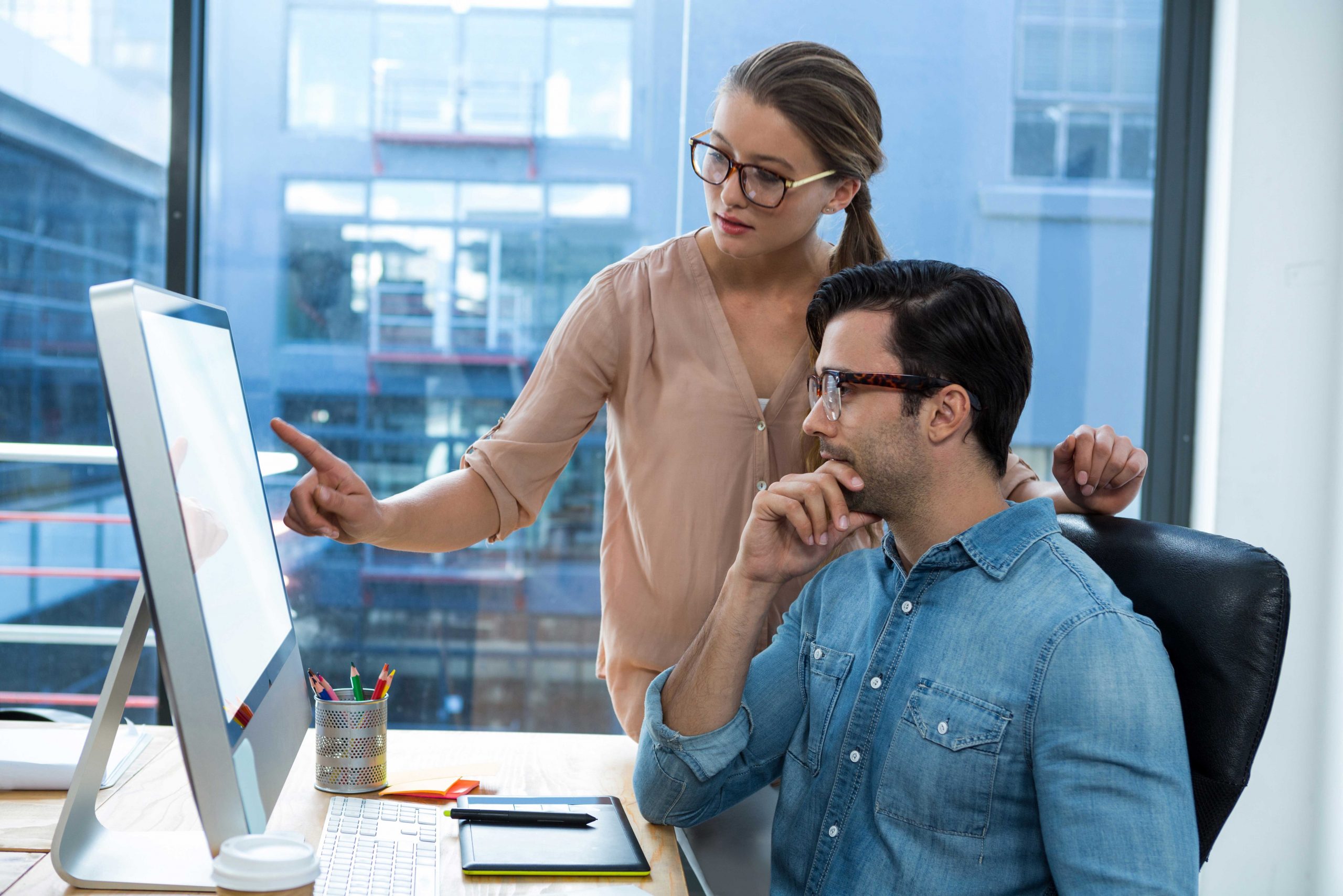 une femme qui montre à un homme comment utiliser un erp